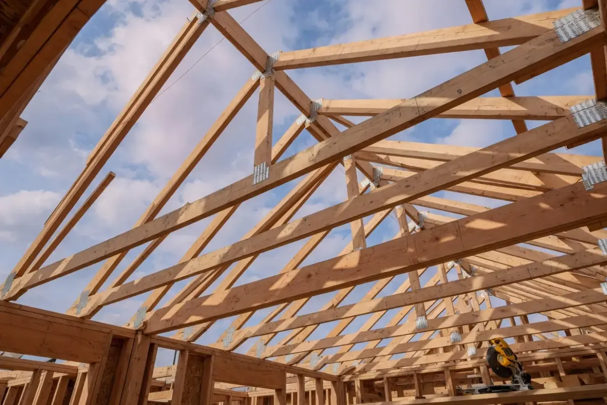 Houten kapconstructie met spanten en gordingen op een woning in aanbouw